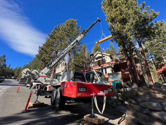 A crane loading a beam on a home addition in Incline Village, NV