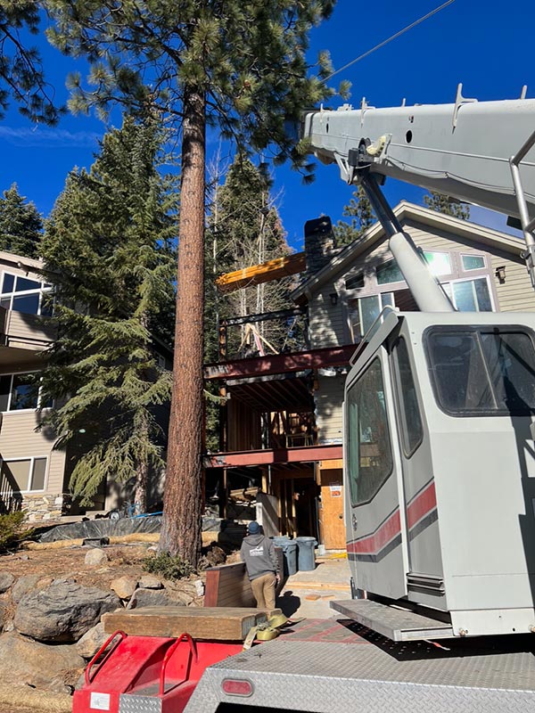 A crane loading a beam on a home addition in Incline Village, NV